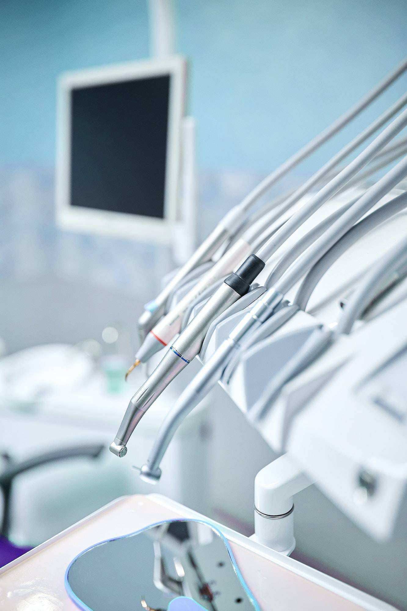 Modern metallic dentist tools and burnishers on a dentist chair
